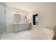 Modern bathroom features marble floors, a double vanity, and a soaking tub with a view at 115 Alcovy Ter, Alpharetta, GA 30009