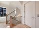 Bright staircase with wood railing and black iron spindles next to a window and white door at 115 Alcovy Ter, Alpharetta, GA 30009