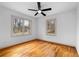 A bright bedroom featuring two windows, a ceiling fan, and gleaming hardwood floors at 1179 Aleamo Dr, Marietta, GA 30062