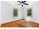 Empty bedroom featuring hardwood floors, a ceiling fan, two windows with views to the outside, and neutral paint at 1179 Aleamo Dr, Marietta, GA 30062