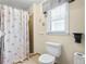 Cozy bathroom with cream colored walls, a white toilet, and a shower with curtain at 4203 Deerbrook Sw Way, Lilburn, GA 30047