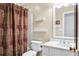 Full bathroom with a white toilet, white sink, and a shower with a patterned curtain at 4203 Deerbrook Sw Way, Lilburn, GA 30047