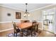 Formal dining room featuring a wooden table, chandelier, and access to the kitchen at 4203 Deerbrook Sw Way, Lilburn, GA 30047