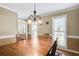 Sun-filled dining room with wainscoting, chandelier, and large windows at 4203 Deerbrook Sw Way, Lilburn, GA 30047