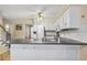 Well-lit kitchen with an island and bright white cabinets, conveniently located adjacent to the staircase at 4203 Deerbrook Sw Way, Lilburn, GA 30047