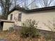 Side exterior of a home with light beige siding, small shed and minimal landscaping at 6385 Gordon St, Lithia Springs, GA 30122