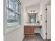 Bright bathroom with a wood vanity, light countertop, and a window with a view to the backyard at , Kennesaw, GA 30152