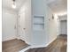 Well-lit hallway with neutral paint, white trim, coat closet, and modern wood flooring at , Kennesaw, GA 30152