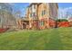Backyard with a well-maintained lawn, brick and wood exterior, and a deck, perfect for outdoor enjoyment at 1654 Summersweet Ln, Dacula, GA 30019