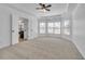 Spacious bedroom with plush carpeting, tray ceiling, ceiling fan, and natural light from a bay window at 1654 Summersweet Ln, Dacula, GA 30019