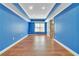 Bedroom with a large window, blue walls, and wood-look floors, offering a bright and airy space at 1654 Summersweet Ln, Dacula, GA 30019