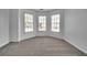 Bright bedroom featuring three large windows and neutral carpet at 1654 Summersweet Ln, Dacula, GA 30019