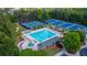 A beautiful aerial view of a large swimming pool area surrounded by lush trees and well-maintained landscaping at 1654 Summersweet Ln, Dacula, GA 30019