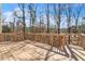 Large, sunny wooden deck with railing overlooking the yard and trees at 1654 Summersweet Ln, Dacula, GA 30019