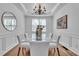 Elegant dining room boasting modern decor, a glass-top table, and natural light from the window at 1654 Summersweet Ln, Dacula, GA 30019