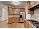 Kitchen features stainless steel refrigerator and appliances, tiled backsplash, and wooden floor at 1654 Summersweet Ln, Dacula, GA 30019