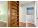 Hallway with custom wooden shelving, offering a glimpse into a brightly lit bathroom with walk-in tub at 3480 Beech Dr, Decatur, GA 30032