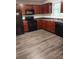Traditional kitchen featuring wood cabinets, black appliances, and laminate floors at 5175 Hanover St, Atlanta, GA 30349