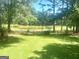 Picturesque backyard with a view of a peaceful pond, surrounded by lush greenery and a fence at 704 Euel Dr, Mcdonough, GA 30252