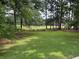 Private fenced backyard featuring large lawn and serene pond view for outdoor enjoyment at 704 Euel Dr, Mcdonough, GA 30252