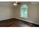 Bright bedroom featuring dark wood floors and a large window with an arched top allowing natural light at 704 Euel Dr, Mcdonough, GA 30252