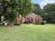 Charming brick home with lush green lawn and mature trees offering great curb appeal at 704 Euel Dr, Mcdonough, GA 30252