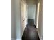 Hallway featuring hard surface flooring and a view of a bright room with natural light at 704 Euel Dr, Mcdonough, GA 30252