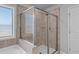 Modern bathroom with a glass-enclosed shower, tiled walls, and a bright window at 7630 Rambling Vale, Cumming, GA 30028