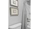 Bright bathroom featuring gray shower curtain and floral art at 7630 Rambling Vale, Cumming, GA 30028