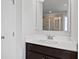 Contemporary bathroom with a dark vanity, white countertop, and large mirror at 7630 Rambling Vale, Cumming, GA 30028