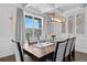 Dining room with large windows, modern light fixture, hardwood floors, and elegant chairs at 7630 Rambling Vale, Cumming, GA 30028