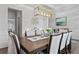 Elegant dining room features a wooden table, seating for eight, modern lighting and neutral wall colors at 7630 Rambling Vale, Cumming, GA 30028