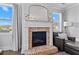 Close-up of a brick fireplace with a white mantel and decorative accents, flanked by windows at 7630 Rambling Vale, Cumming, GA 30028