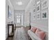 Bright hallway with hardwood floors, elegant lighting, decorative accents, and a view to the front door at 7630 Rambling Vale, Cumming, GA 30028