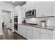 Modern kitchen featuring a gas range, stainless steel appliances, granite countertops, and white cabinets at 7630 Rambling Vale, Cumming, GA 30028