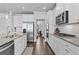 A kitchen featuring white cabinets, granite countertops, stainless steel appliances and dark wood flooring at 7630 Rambling Vale, Cumming, GA 30028