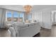 Inviting living room with ample seating, a modern chandelier, and large windows providing scenic views and natural light at 7630 Rambling Vale, Cumming, GA 30028
