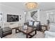 This living room has hardwood floors, a staircase, a media center, and a comfortable leather couch at 7630 Rambling Vale, Cumming, GA 30028