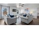 Comfortable living room with contemporary sofas, a ceiling fan, and bright windows at 7630 Rambling Vale, Cumming, GA 30028