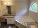 Bright bathroom featuring a soaking tub beneath a window and a granite vanity with ample counter space and storage at 153 Rockport Dr, Mcdonough, GA 30253