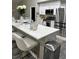 Modern kitchen with white cabinets, stainless steel appliances, quartz countertops and an island with barstool seating at 153 Rockport Dr, Mcdonough, GA 30253