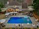 Aerial view of a backyard oasis with a large pool, lounge chairs, and an outdoor dining area at 3140 Sawnee Lake Trl, Cumming, GA 30040