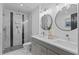Modern bathroom featuring double vanity, updated lighting, and tiled glass shower at 935 Tiber Cir, Alpharetta, GA 30022