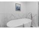 A freestanding bathtub with a modern faucet, marble wall and towel at 935 Tiber Cir, Alpharetta, GA 30022