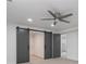 Bedroom with ceiling fan and barn door leading to walk-in closet and bathroom at 935 Tiber Cir, Alpharetta, GA 30022