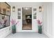 Bright entryway with sidelights, fresh flowers, and a glimpse into a cozy living room with fireplace at 935 Tiber Cir, Alpharetta, GA 30022
