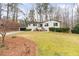 Landscaped front yard of a single-story home with blooming flowers and a paved driveway at 935 Tiber Cir, Alpharetta, GA 30022