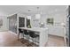 Modern kitchen with white cabinets, a quartz island with seating, and sleek, decorative wall accents at 935 Tiber Cir, Alpharetta, GA 30022