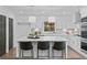 Bright white kitchen featuring a large island, modern pendant lighting, and stainless steel appliances at 935 Tiber Cir, Alpharetta, GA 30022