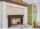 Cozy fireplace with stone surround, a wooden mantel, and a green cabinet sitting on wood floor at 1507 Country Park Se Dr, Smyrna, GA 30080